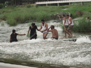 Niwiditha and Manjunath helping Vidya, with other Indian guys enjoying the water.  Yes, that is the traditional Indian version of a bathing costume.